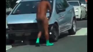 Vaccine Zombie or on Drugs? Naked dude rips bumper off of car in traffic