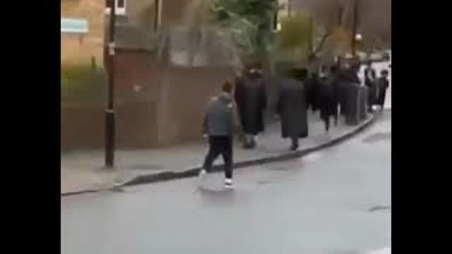 BLACK MAN HERDING A GROUP OF JEWS WITH A STICK IN LONDON