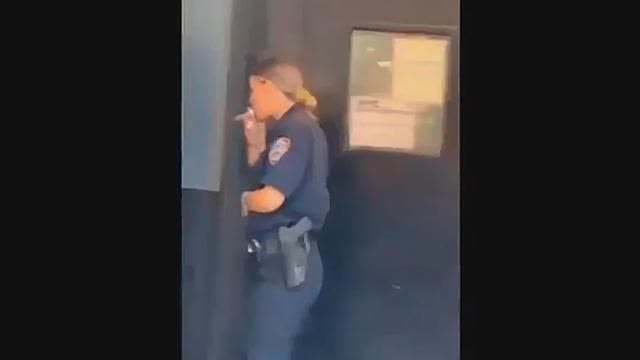 NYC Cop taking a smoke break. But what is she smoking? That is not a cigarette.