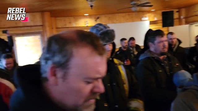 surrounded by the Canadian government, they say a prayer before continuing to hold